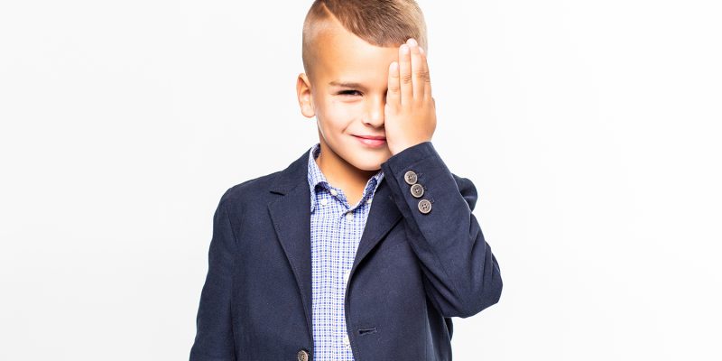 scared boy with his hands covering the eyes on a white background